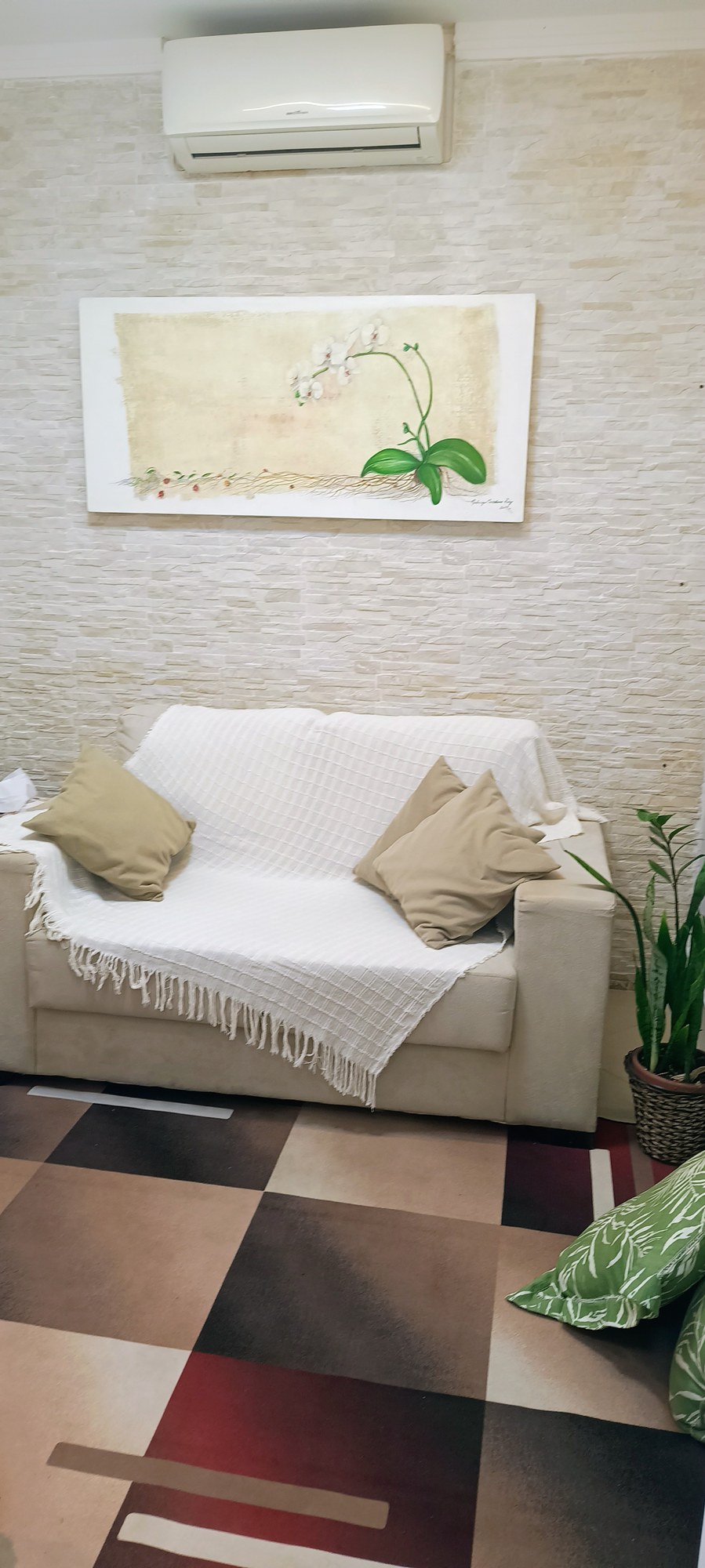 Sala de atendimento com sofá claro e tapete